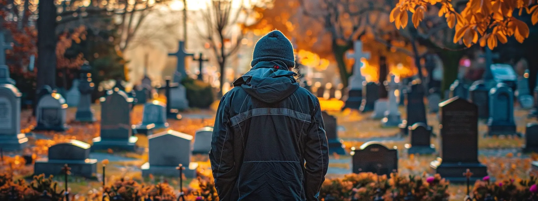 a person standing in front of a cemetery, looking contemplative and thoughtful.